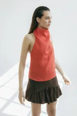 Top sin mangas color naranja, con cuello halter y espalda descubierta. Confeccionado en lino.
