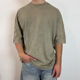 Remera gris con efecto lavado, corte oversize y mangas 3/4.