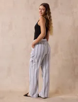 Pantalón cargo de lino color blanco, marca Marissa Olivia. Tiene pretina ancha elastizada con lazo de ajuste, bolsillos inclinados delanteros y bolsillos laterales con botón.
