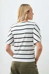 Remera de punto con rayas horizontales negras sobre fondo blanco, mangas cortas con volados.