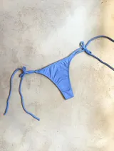 Bombacha de bikini color celeste con tiras finas para atar a los costados.