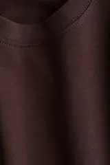 Remera marrón de corte cuadrado, cuello redondo y mangas cortas amplias.