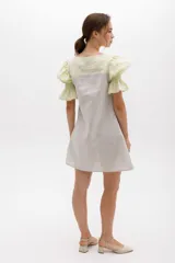 Vestido corto con cuerpo a rayas verticales en tonos beige y blanco, mangas cortas abullonadas y canesú superior en color negro.