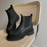 Botas Chelsea negras de cuero con elásticos laterales, tirador trasero y suela track.