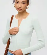 Cardigan de punto acanalado color bordó de la marca Blue Steel, con cuello redondo y cierre frontal de cremallera doble. Posee un calce ajustado, largo corto y mangas largas.