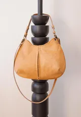 Cartera de cuero color beige con forro interior, cuenta con doble correa desmontable.