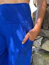Pantalón palazzo azul eléctrico de lycra de algodón con tiro alto, piernas anchas, bolsillos laterales y faja ancha en la cintura.