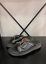 Sandalias negras de ecocuero con plataforma y hebilla metálica.