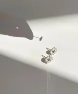 Par de aros pequeños de plata 950 con forma de flor y detalles de piedras azules.