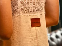 Vestido largo color beige con breteles finos y detalles de encaje en el escote.