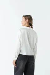 Camisa blanca de satén con corte relajado y largo a la cadera.