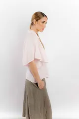 Camisa de lino color blanco con cuello clásico, cierre frontal de botones y mangas anchas de estilo acampanado.