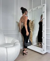 Vestido midi negro de tejido acanalado, al cuerpo con espalda entrelazada que se ajusta al talle.