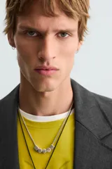 Blazer negro de corte relajado con cuello de solapa de muesca desmontable, manga larga, bolsillos frontales ocultos y cierre frontal con botones.