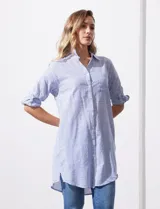 Camisola larga de algodón color blanco, marca Dash. Tiene cuello con solapa, abertura central con botones, bolsillo aplicado en el pecho, mangas regulables con presilla y botón, y bolsillos laterales en la costura.