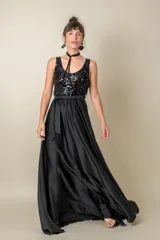 Vestido largo de fiesta negro, con corpiño de tul bordado y falda de satén liso. Incluye lazo de satén en la cintura.