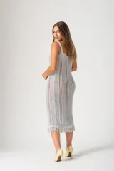 Vestido midi tejido al crochet color gris plata, con breteles finos y flecos en el ruedo.