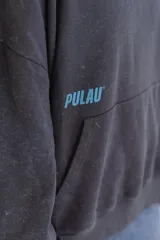 Canguro azul con capucha, bolsillo tipo canguro y puños y cintura acanalados. Estampado pequeño en el pecho con el texto "PULAU EST. 2023 MVD UY".