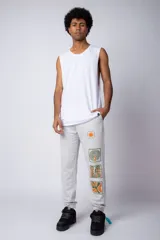 Pantalón de jogging gris claro con puños elásticos, cintura con cordón ajustable y estampado con motivos geométricos en la pierna izquierda.