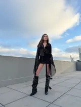 Vestido corto de malla transparente color negro, con mangas largas acampanadas y cintas para atar en la cintura.