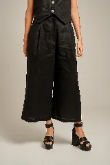 Pantalón de lino color naranja, de tiro alto y pierna ancha, con pinzas delanteras y cintura marcada.