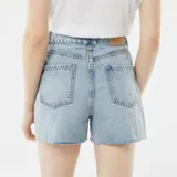 Short de jean celeste con efecto desgastado y terminaciones desflecadas.