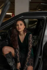 Vestido corto negro de terciopelo con escote en V, mangas largas de encaje y falda con volantes de encaje.