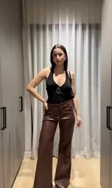 Body negro de lycra con escote halter y detalle de hebilla plateada en el centro.