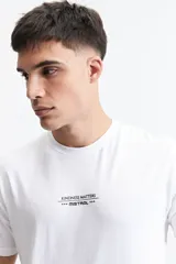Remera blanca de manga corta con cuello redondo y estampado pequeño en el pecho.