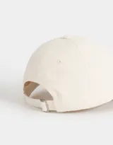 Gorra de béisbol bicolor, con la parte superior color crema y la visera azul denim. Tiene bordada la frase "New York" en azul marino.