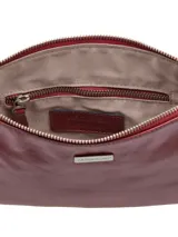 Cartera de mano rectangular color rojo charol con cierre superior y correa de muñeca extraíble.