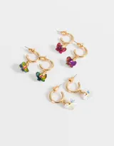 Set de tres pares de aros tipo argolla dorados con dijes de mariposas colgantes en diferentes colores: multicolor, blanco iridiscente, violeta y fucsia.
