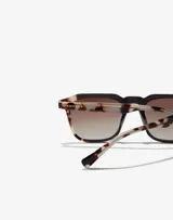 Lentes de sol unisex Hawkers con montura cuadrada negra y patillas con estampado carey.