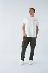 Pantalón cargo color marrón, corte slim, con cierre y botón en la cintura, pasacintos y bolsillos cargo con botones.