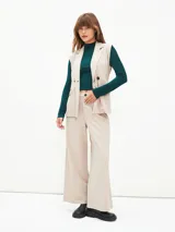 Chaleco negro con solapas cruzadas, doble botonadura, bolsillos laterales y lazo para atar en la cintura.