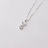 Set de joyería en plata 925 que incluye un collar con dije en forma de infinito y aros a juego, decorados con circonias.