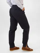 Pantalón de vestir color café con pinzas, bolsillos laterales y tobillos ajustados con botones.