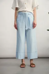 Pantalón capri celeste con lazo en la cintura, bolsillos delanteros y ruedo con dobladillo.