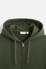 Sudadera negra relaxed fit de algodón compacto con interior en rizo, cuello con capucha ajustable, manga larga, bolsillos frontales tipo canguro, acabados en rib y cierre frontal con cremallera.