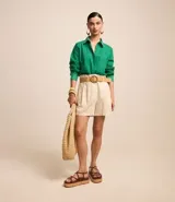 Short clochard azul marino de viscolino con trabillas en la cintura, cinturón con hebilla de madera y pliegues.