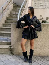 Vestido corto negro metalizado, con escote en V, mangas largas acampanadas, cintura elastizada y falda con volados.