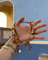 Collar corto con cordón de algodón color menta y flores de bronce.