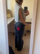 Pantalón de jean gris oscuro con corte recto y bolsillos traseros con apliques de estrellas rojas.