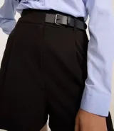 Short de sastrería color verde oliva, de corte recto y cintura alta. Presenta pliegues frontales y un detalle de medio cinturón con hebilla lateral.