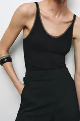 Musculosa blanca de breteles finos y escote redondo con detalle de tul a tono.