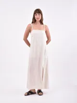 Vestido largo color coral con breteles finos y tajo lateral.