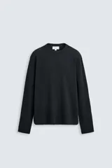 Camiseta blanca de manga larga con cuello redondo y textura cuadriculada.