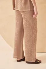 Pantalón tejido color crudo, con diseño calado de corazones y arabescos. Corte palazzo.