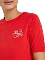 Vestido rojo de algodón con cuello redondo y mangas cortas. Presenta un logo de Tommy Hilfiger bordado en blanco en el pecho y la bandera de la marca bordada en la manga.