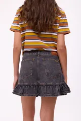 Falda corta de jean azul oscuro con efecto lavado, tiro medio/bajo y un volante fruncido en el ruedo inferior.